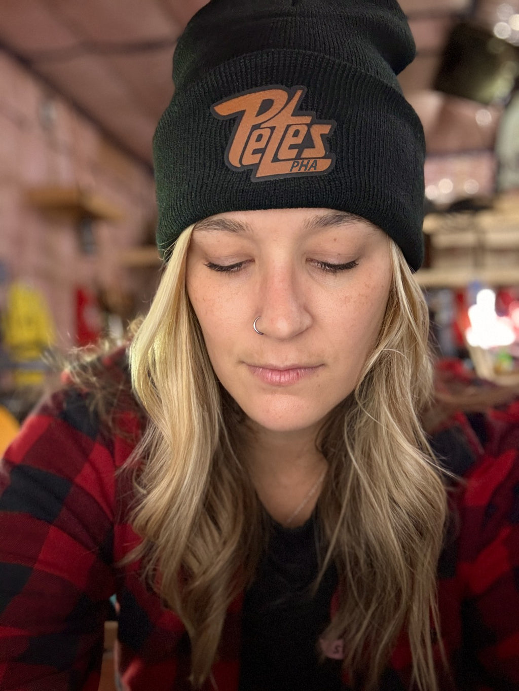 Person wearing a black beanie with 'Pete's' logo in a casual setting