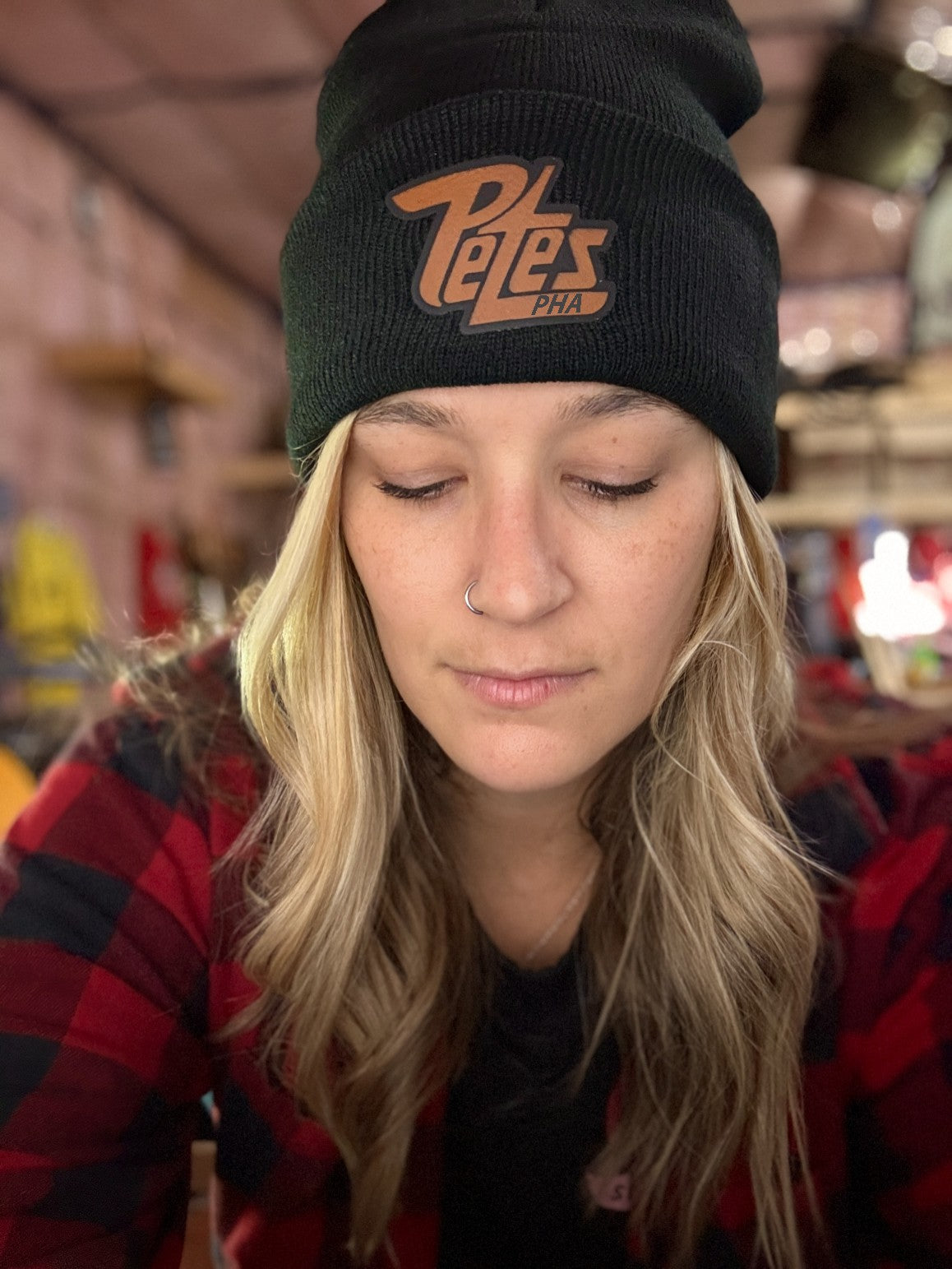 Person wearing a black beanie with 'Pete's' logo in a casual setting